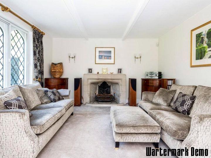 Five-Bedroom Town House on Rue de Rivoli - Sitting room with two sofas drawn up to an open fireplace beside a leaded window