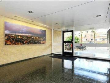 Entrance hall with a glazed street door and a framed cityscape on the brick wall