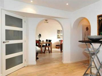 Hallway with arched openings looking through to the dining room