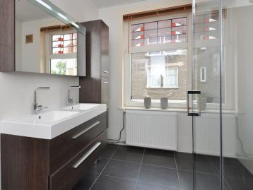 Bathroom with twin basins on a walnut vanity and a glazed walk-in shower
