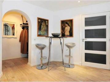 Breakfast bar with two stools beside the arch through to the cloakroom