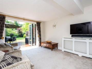Living room whose bi-fold doors are folded back onto the terrace and garden