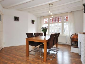 Dining room with an oak table for six under a beamed ceiling